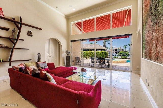 tiled living room featuring a high ceiling and crown molding