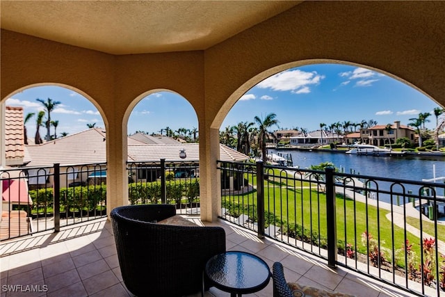 view of patio / terrace with a water view and a balcony