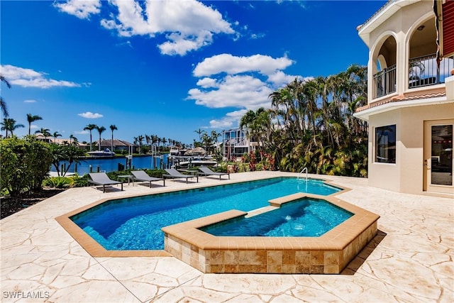 view of swimming pool featuring a water view, an in ground hot tub, and a patio