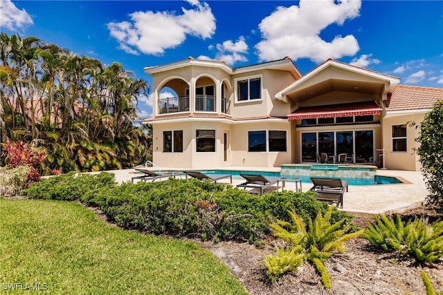 rear view of property featuring a balcony and a patio