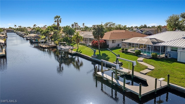 view of dock with glass enclosure, a yard, a swimming pool, and a water view