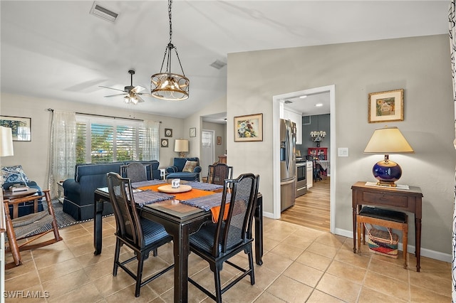 tiled dining room featuring ceiling fan and vaulted ceiling