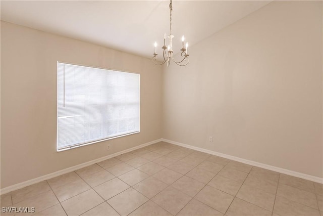 spare room with light tile patterned floors and a chandelier