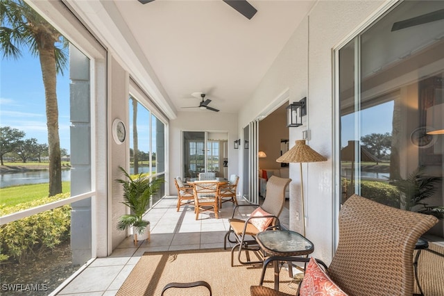 sunroom / solarium with ceiling fan and a water view