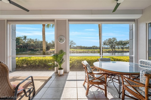 sunroom / solarium with a water view and ceiling fan