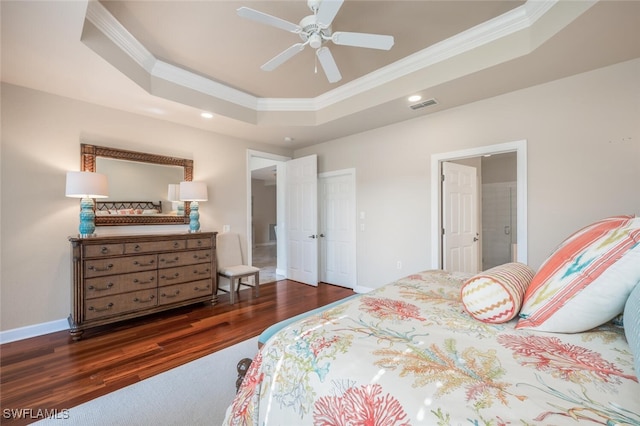 bedroom with ceiling fan, dark wood-type flooring, a tray ceiling, and ornamental molding