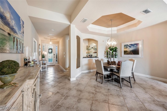 dining room with an inviting chandelier, crown molding, and a tray ceiling