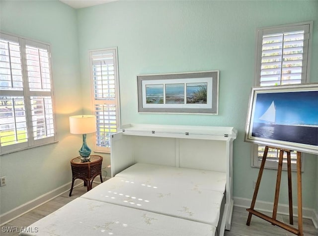 bedroom featuring wood-type flooring and multiple windows