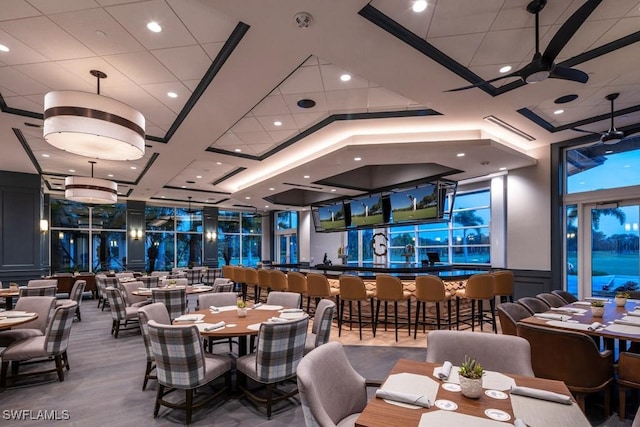 dining space featuring ceiling fan and bar area