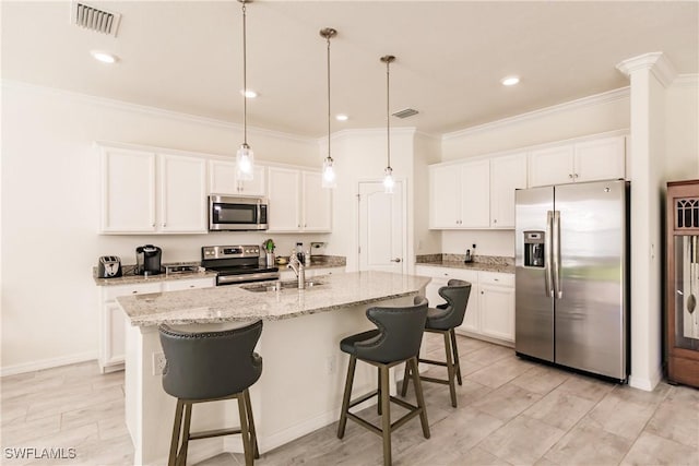 kitchen featuring white cabinetry, a center island with sink, and stainless steel appliances