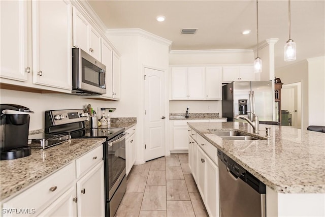 kitchen featuring pendant lighting, white cabinets, ornamental molding, an island with sink, and appliances with stainless steel finishes