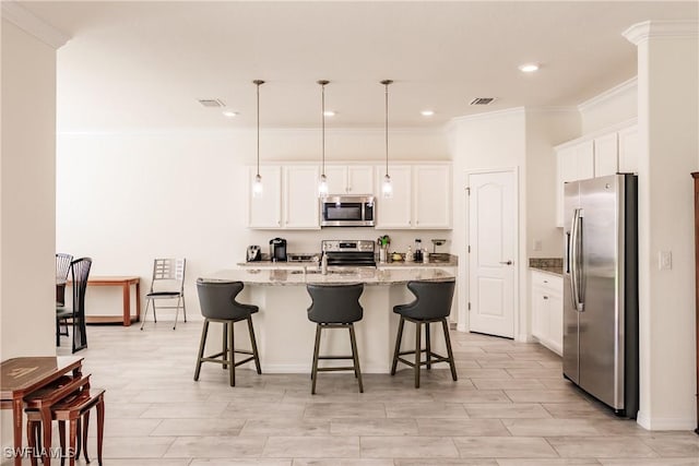 kitchen with white cabinets, decorative light fixtures, light stone counters, and stainless steel appliances