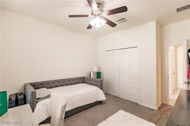 carpeted bedroom featuring ceiling fan and a closet