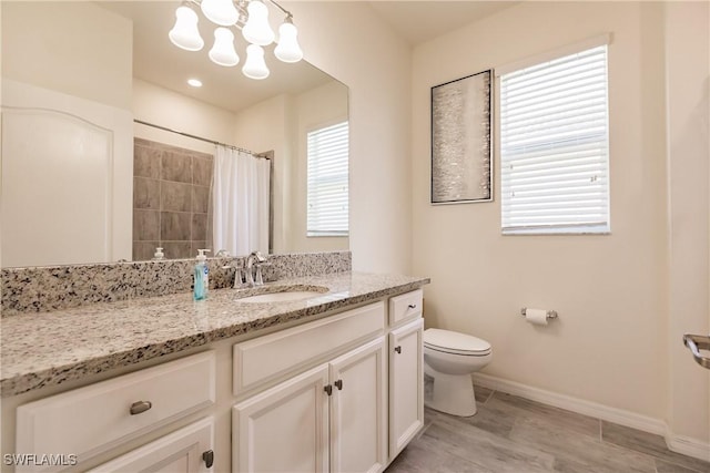 bathroom with a shower with shower curtain, vanity, and toilet