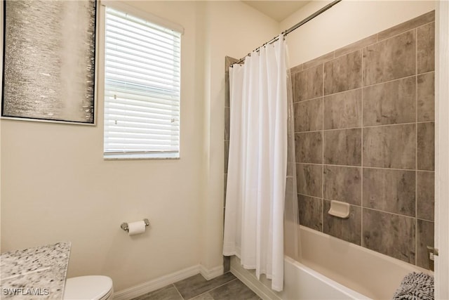 bathroom featuring tile patterned flooring, shower / bath combination with curtain, and toilet