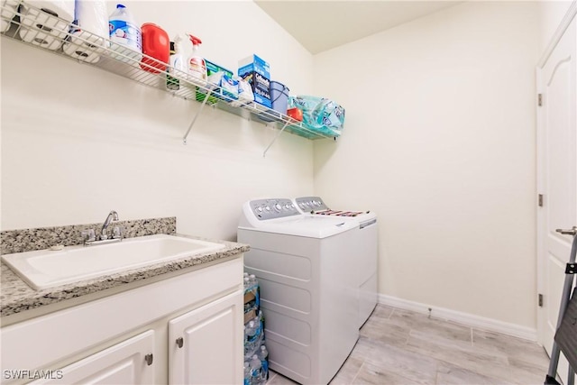 washroom featuring cabinets, separate washer and dryer, and sink