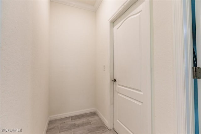 hallway featuring crown molding and light hardwood / wood-style flooring