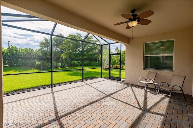 unfurnished sunroom featuring ceiling fan