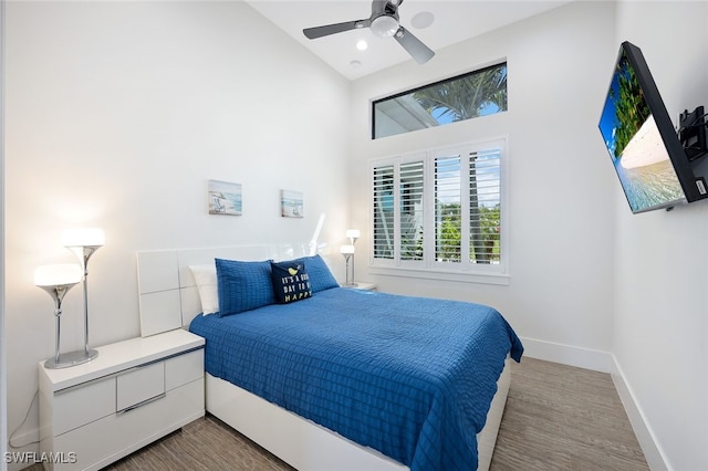 bedroom with ceiling fan, wood-type flooring, and high vaulted ceiling