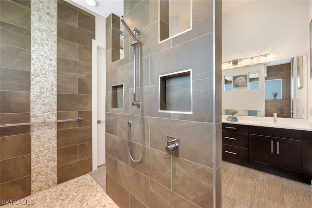 bathroom featuring tiled shower and vanity