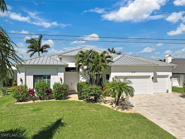 view of front of home with a garage and a front lawn