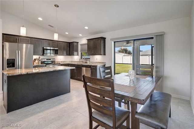 dining area with sink, vaulted ceiling, and light tile patterned flooring