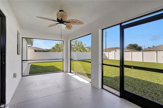 unfurnished sunroom with ceiling fan