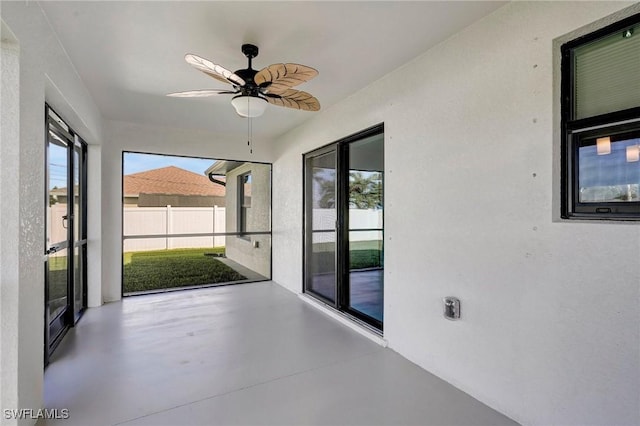 unfurnished sunroom with ceiling fan