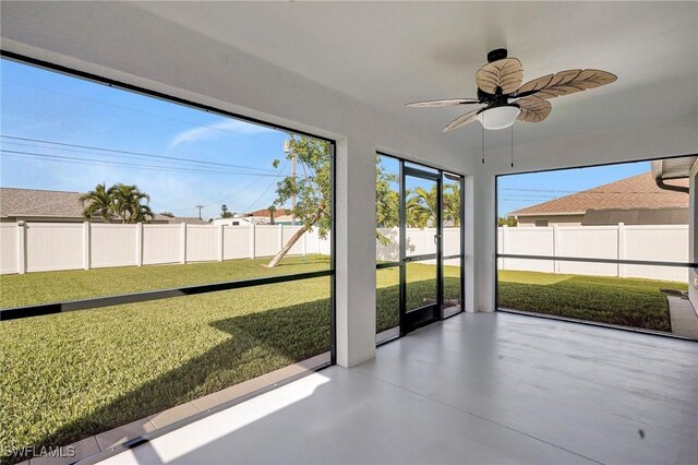 unfurnished sunroom with ceiling fan