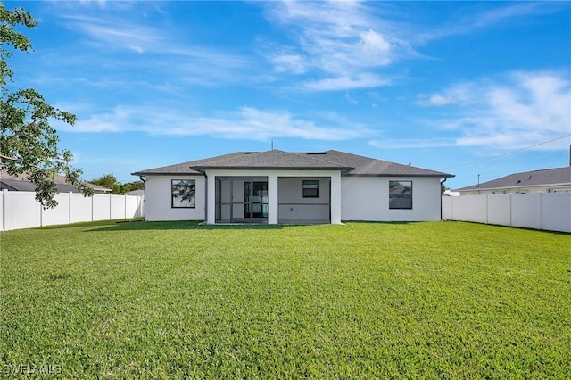 back of property with a sunroom and a lawn