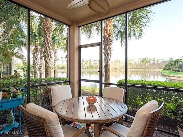 sunroom / solarium with a water view and ceiling fan