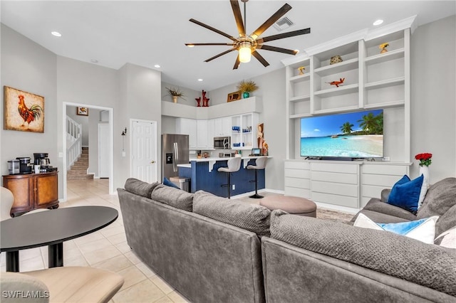 tiled living room with a high ceiling and ceiling fan