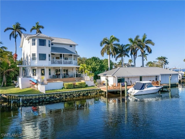 back of property with a balcony and a water view