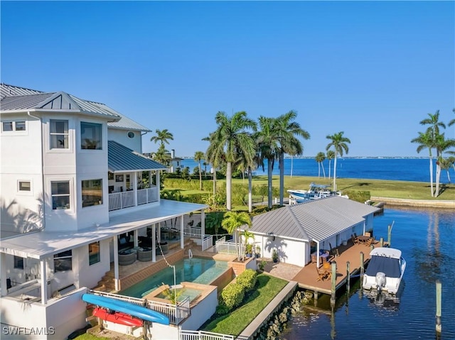 exterior space with a water view, a balcony, a swimming pool with hot tub, and a patio area