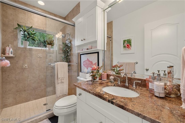 bathroom with vanity, toilet, and a shower with door