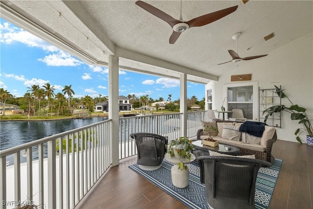 exterior space with a water view, ceiling fan, and an outdoor living space