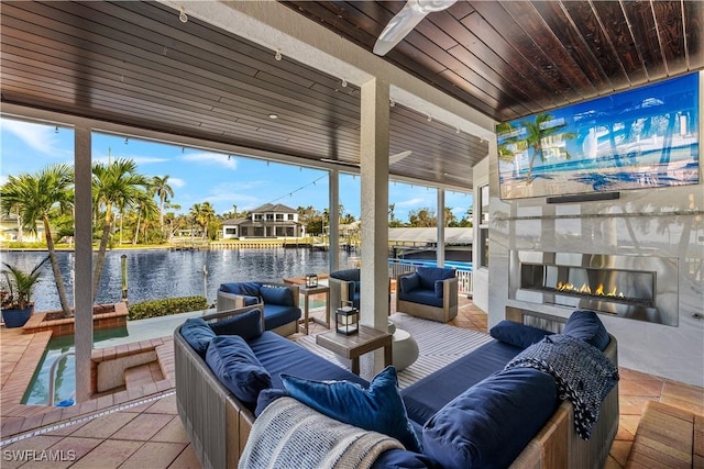 view of patio with ceiling fan and an outdoor living space with a fireplace