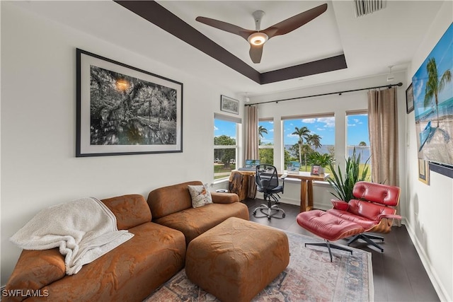 living room with ceiling fan, wood-type flooring, and a tray ceiling