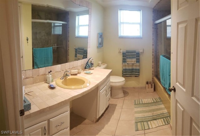 full bathroom featuring tile patterned flooring, vanity, toilet, and shower / bath combination with glass door