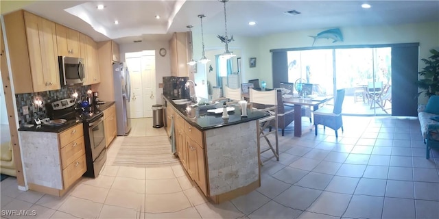 kitchen featuring pendant lighting, light tile patterned floors, light brown cabinetry, tasteful backsplash, and stainless steel appliances