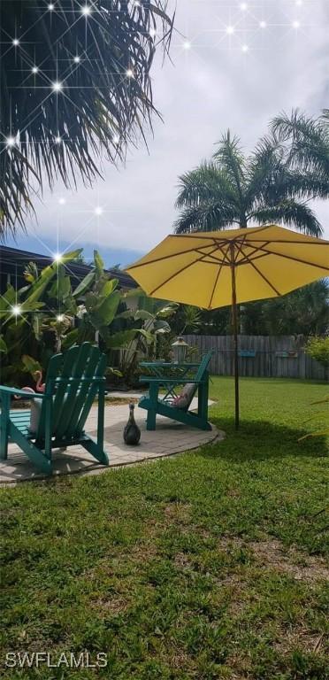 exterior space featuring a patio area, a yard, and fence