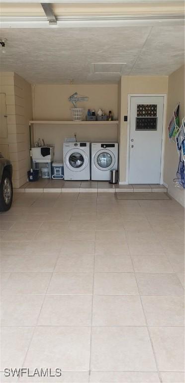 clothes washing area featuring tile patterned floors and washing machine and dryer