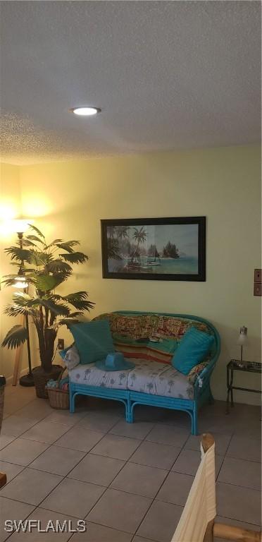 sitting room with a textured ceiling and tile patterned floors