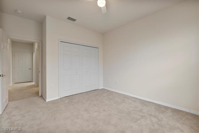 unfurnished bedroom with a closet, ceiling fan, and light colored carpet