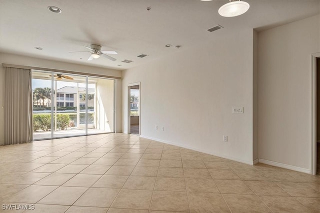 tiled spare room with ceiling fan