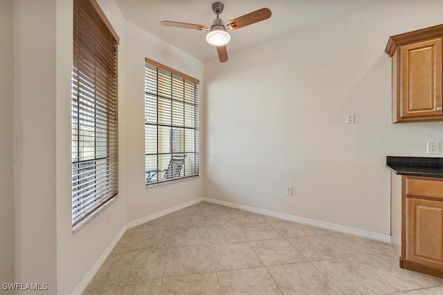 unfurnished dining area featuring ceiling fan and light tile patterned floors