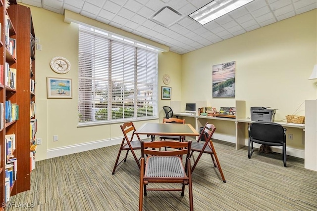 dining room with light colored carpet and a drop ceiling