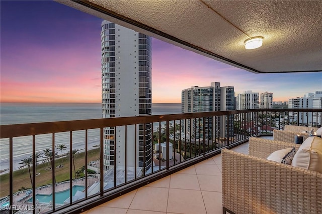 balcony at dusk with a water view and a city view