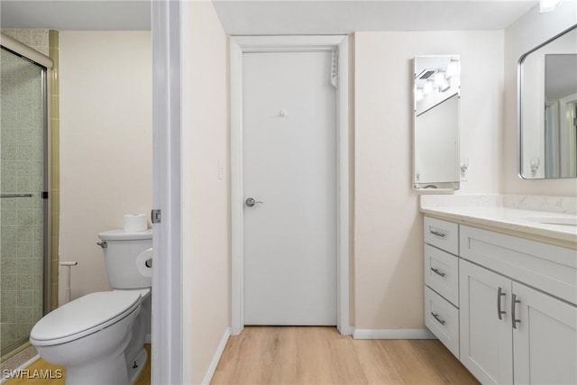 bathroom featuring wood-type flooring, vanity, toilet, and an enclosed shower