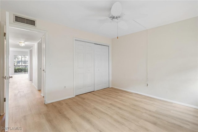 unfurnished bedroom with ceiling fan, light wood-type flooring, and a closet